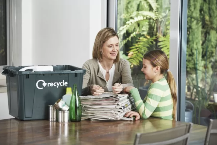 Woman And Girl Preparing Waste Paper For Recycling